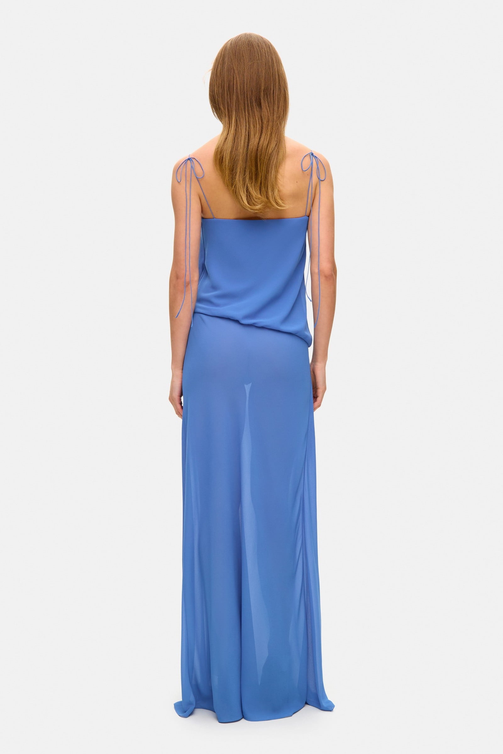 Model in loose maxi Arabella dress with tulip-shaped decorated cups and straps tied into bows back view