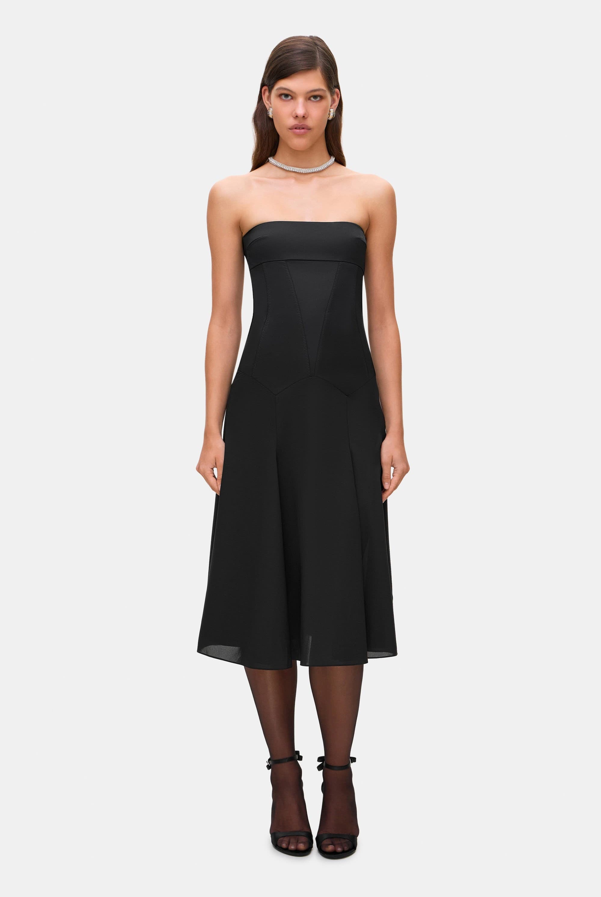 Woman wearing a black strapless Ariella dress on a white background, front view