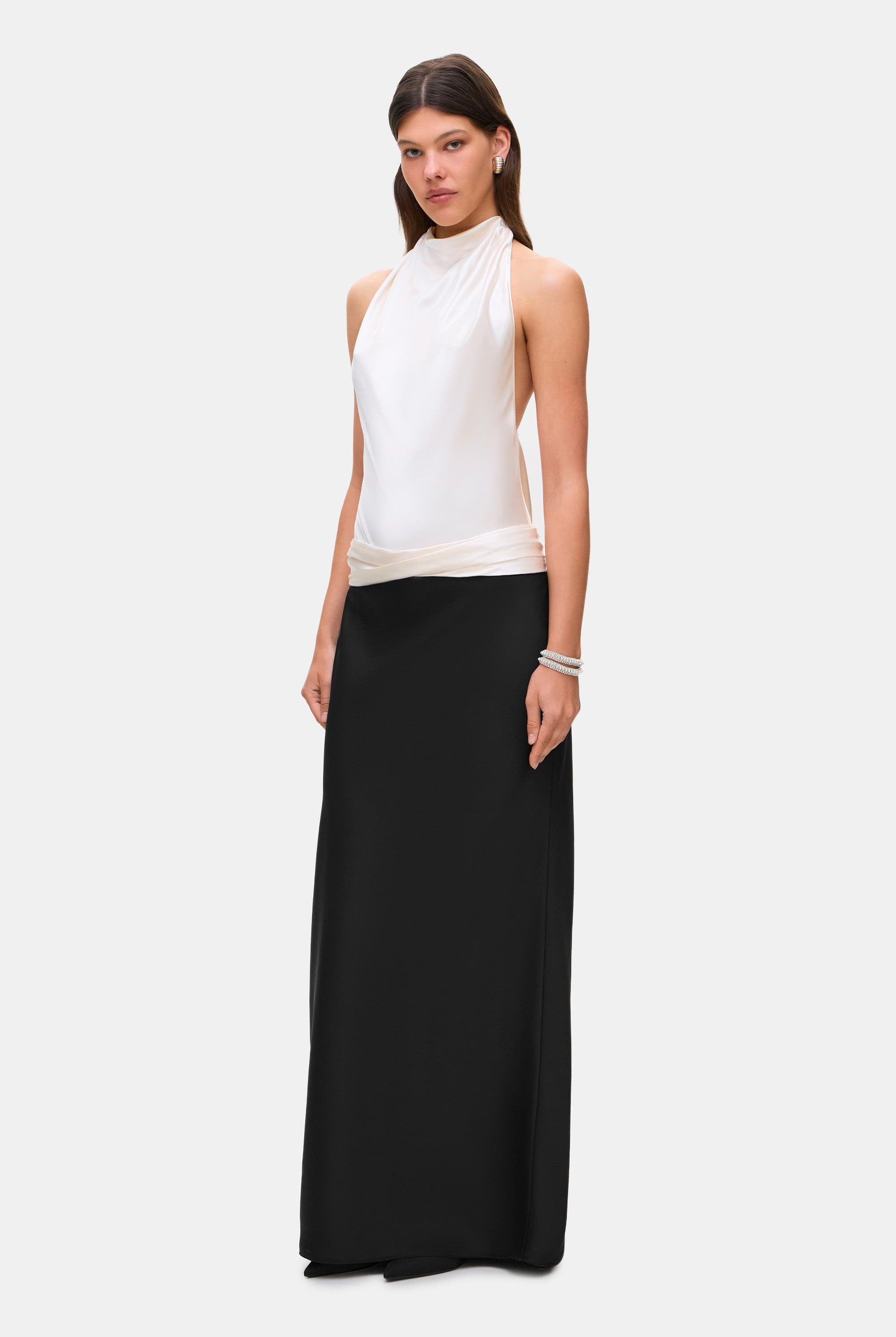 Woman wearing a two-tone Ayla dress with a white top and black skirt on a white background, side view