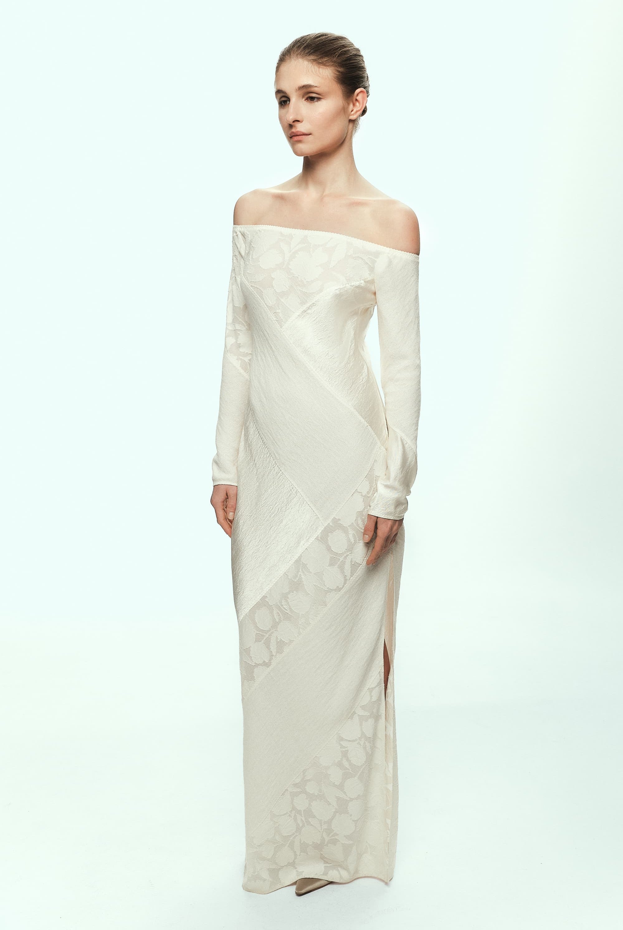 Woman wearing a white off-shoulder Santa dress with floral patterns on a white background, front view