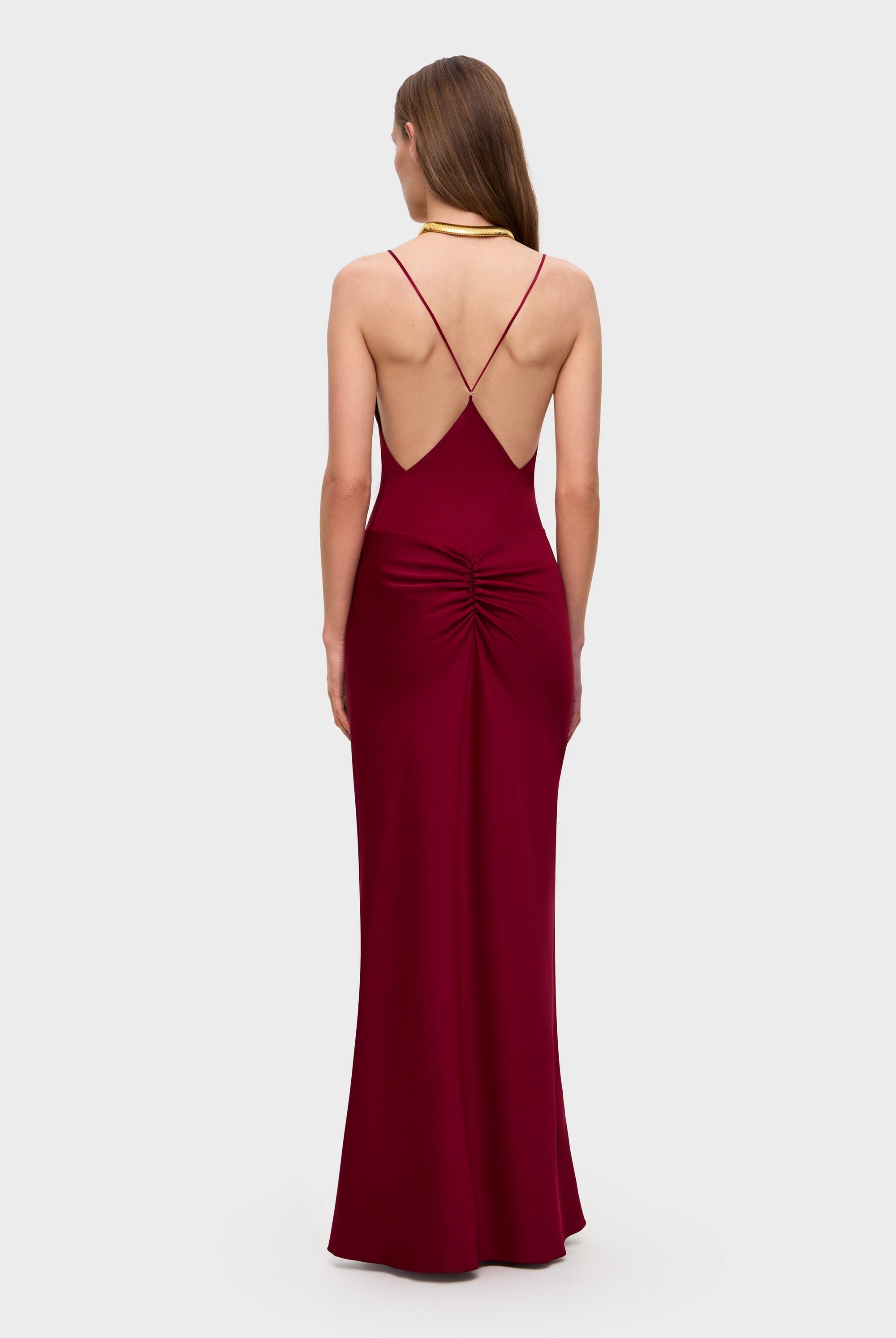 Woman wearing a berry Maltina dress on a white background, back view