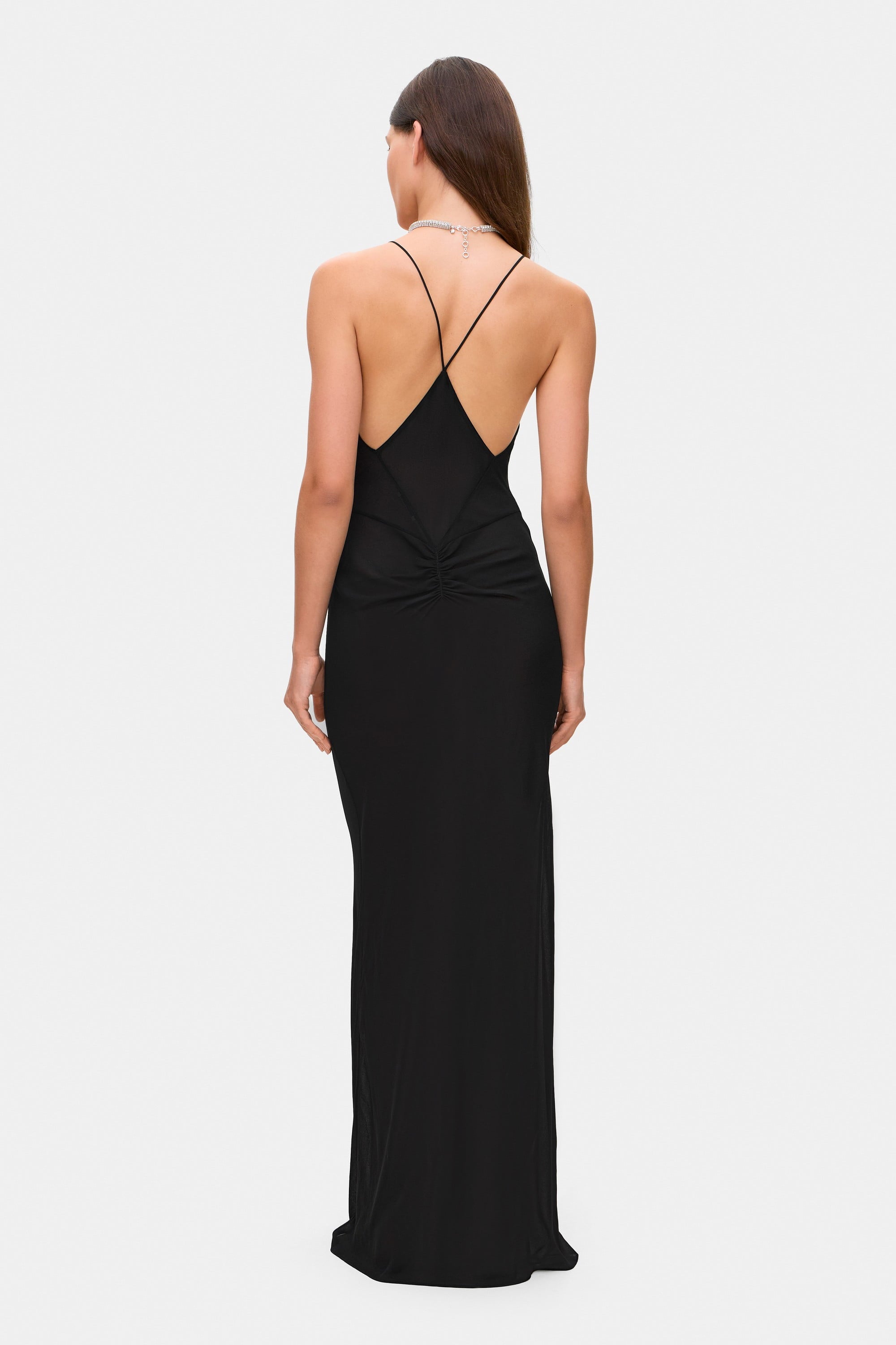 Woman wearing a black Eliana dress on a white background, back view