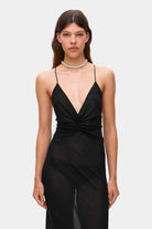 Woman wearing a black Eliana dress on a white background, back view details