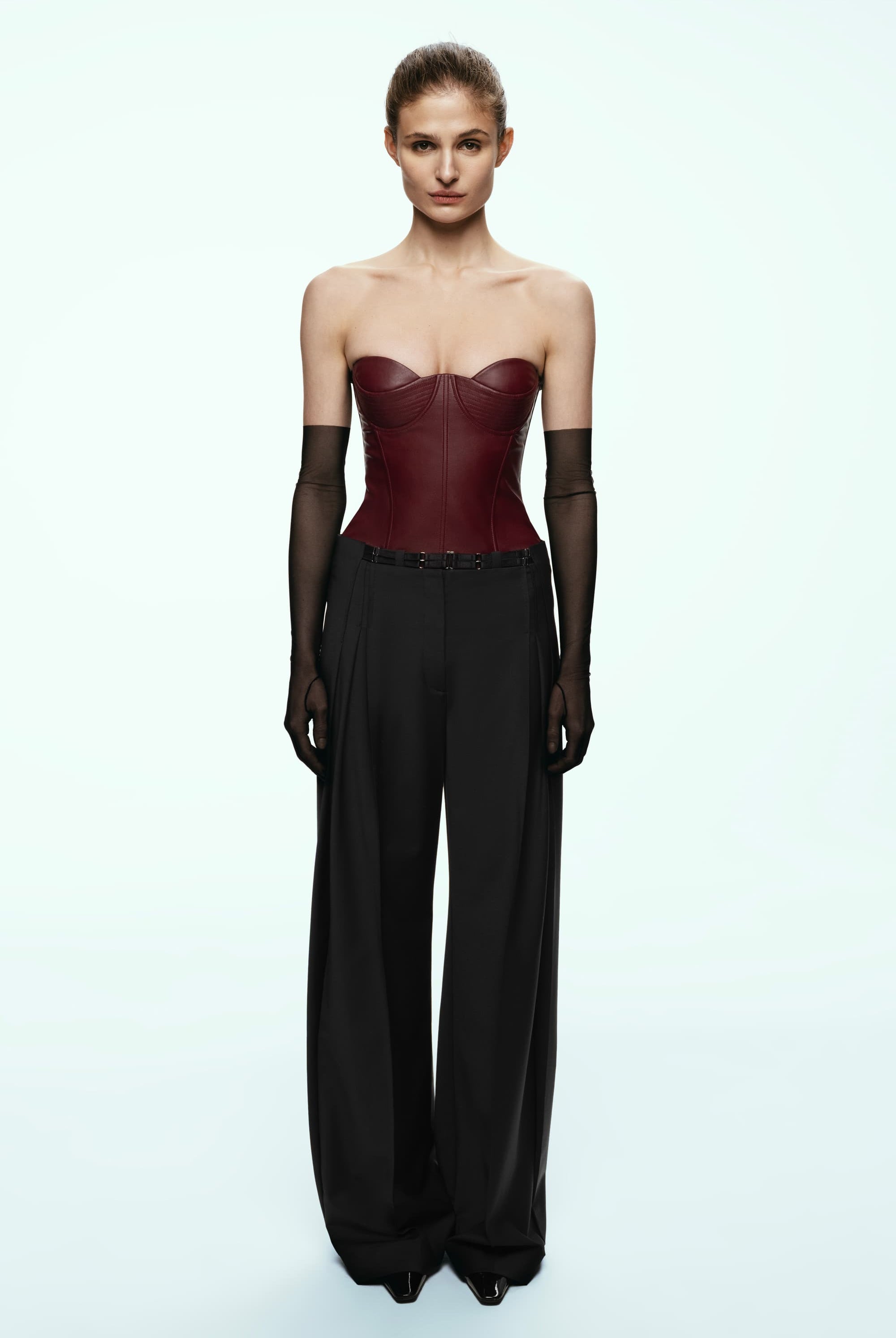 Model wearing a black wide-leg Katherine pants on a light blue background, front view