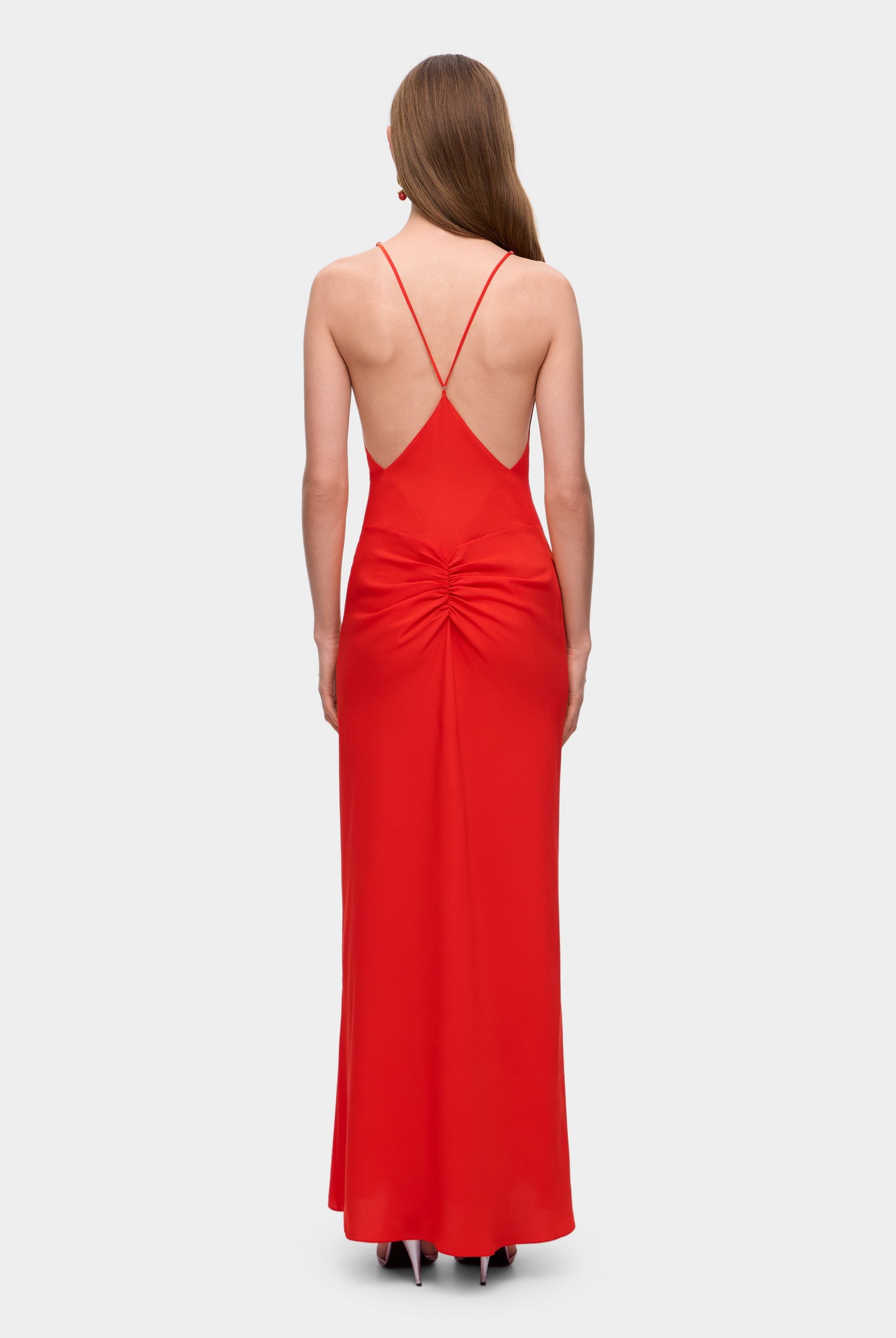 Woman wearing a coral Eliana dress on a white background, back view