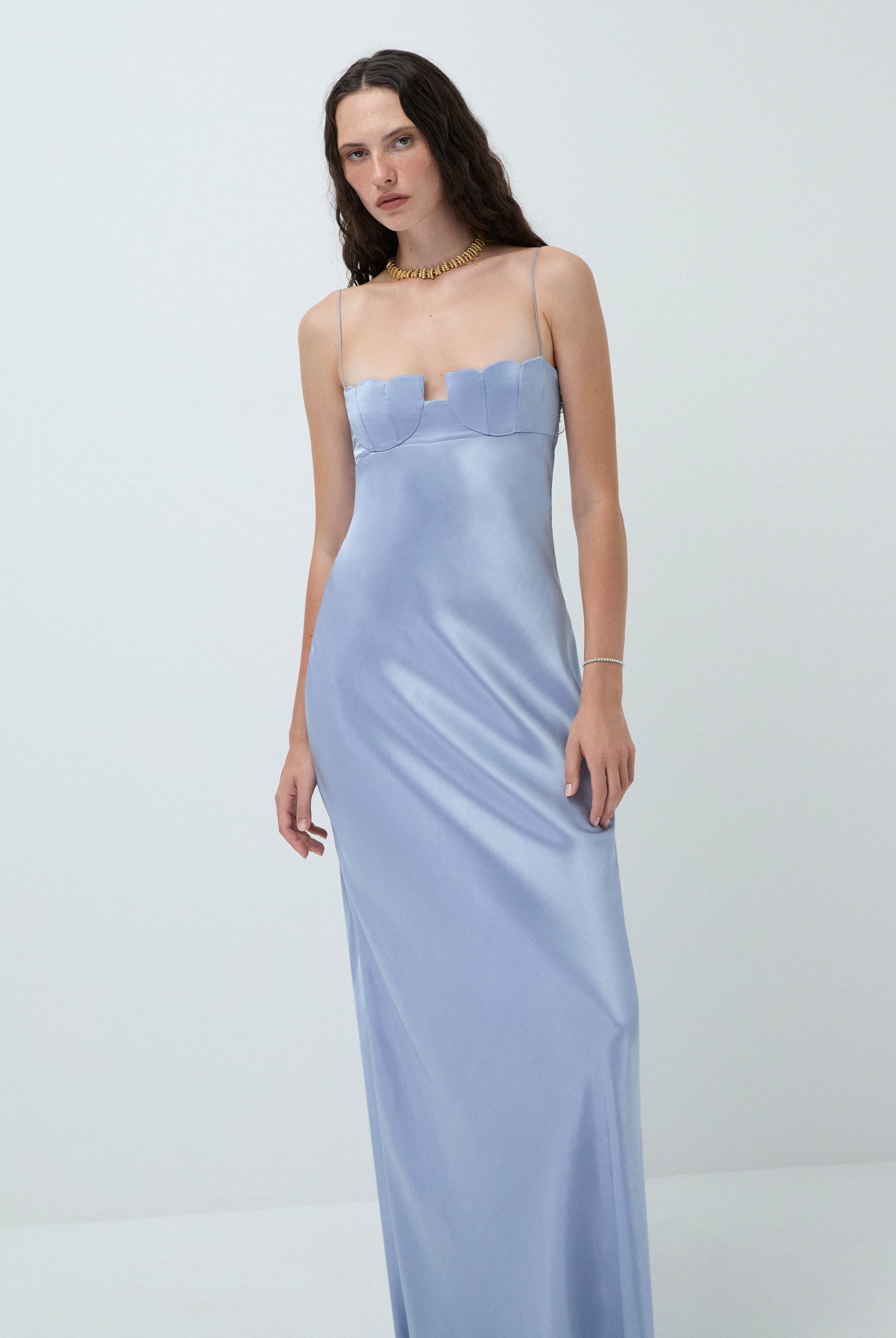 Woman wearing a light blue with thin straps Tulip dress against a white background, front view