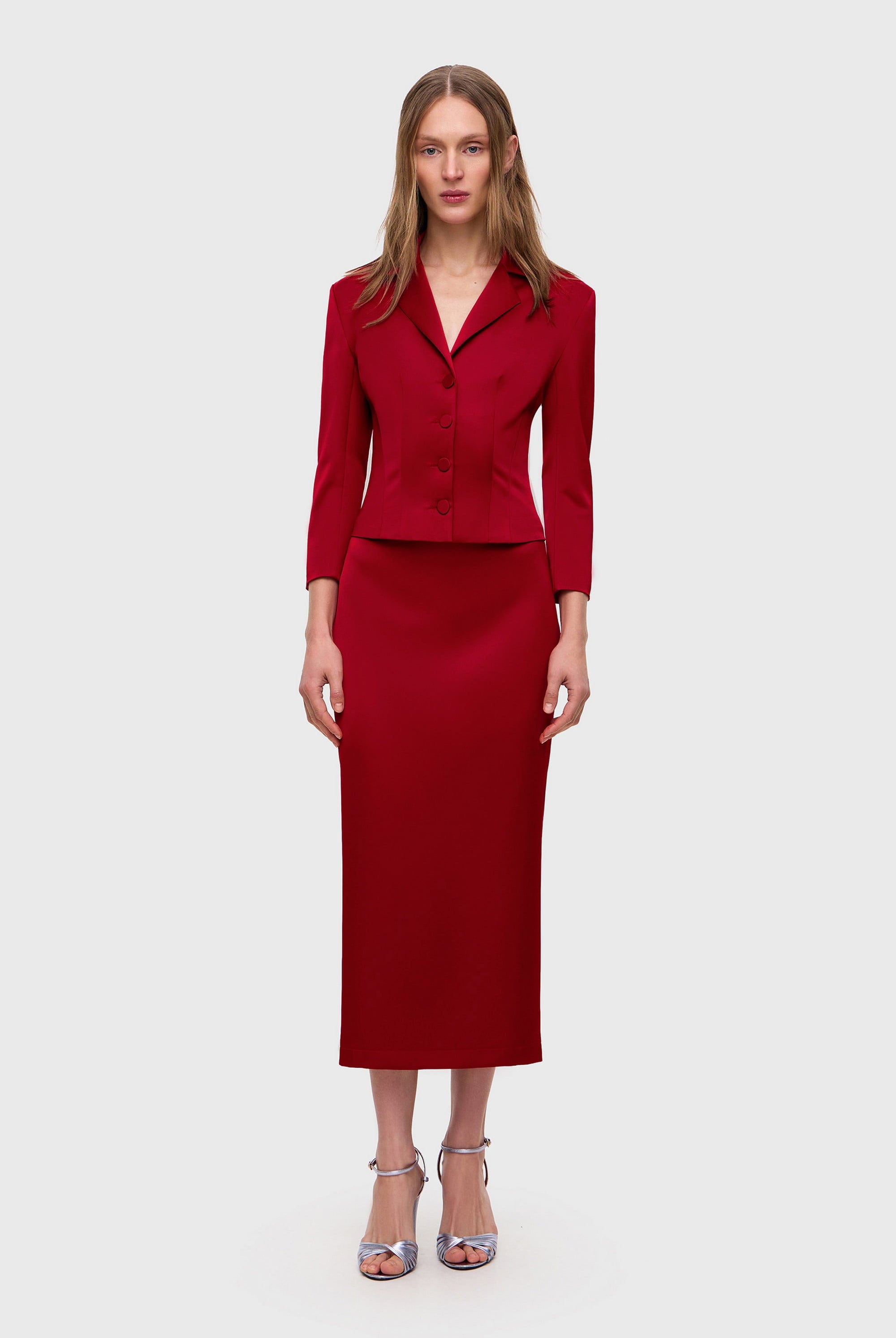 Woman wearing a red Kaya skirt on a white background, front view