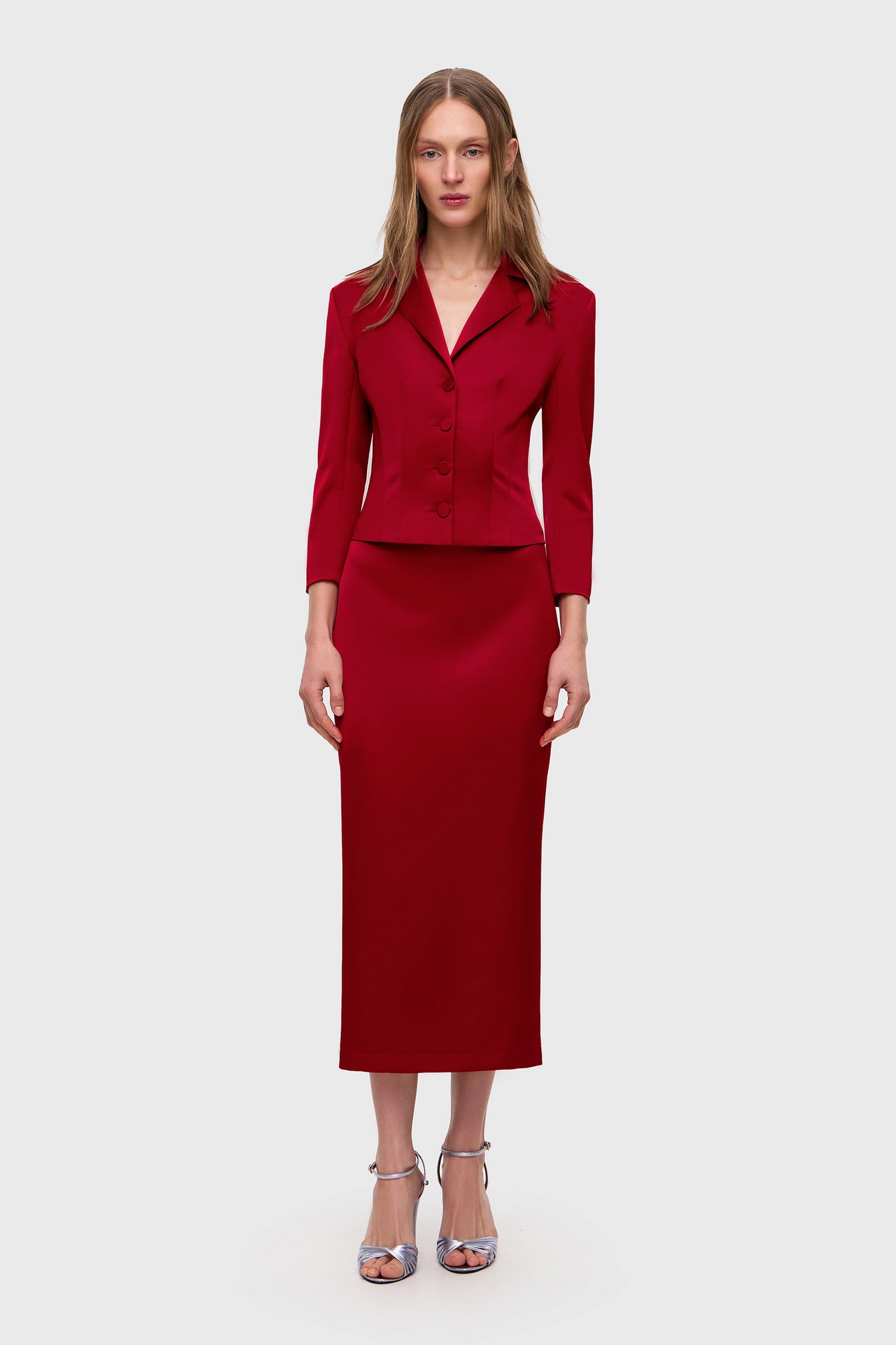 Woman wearing a red Kaya skirt on a white background, front view