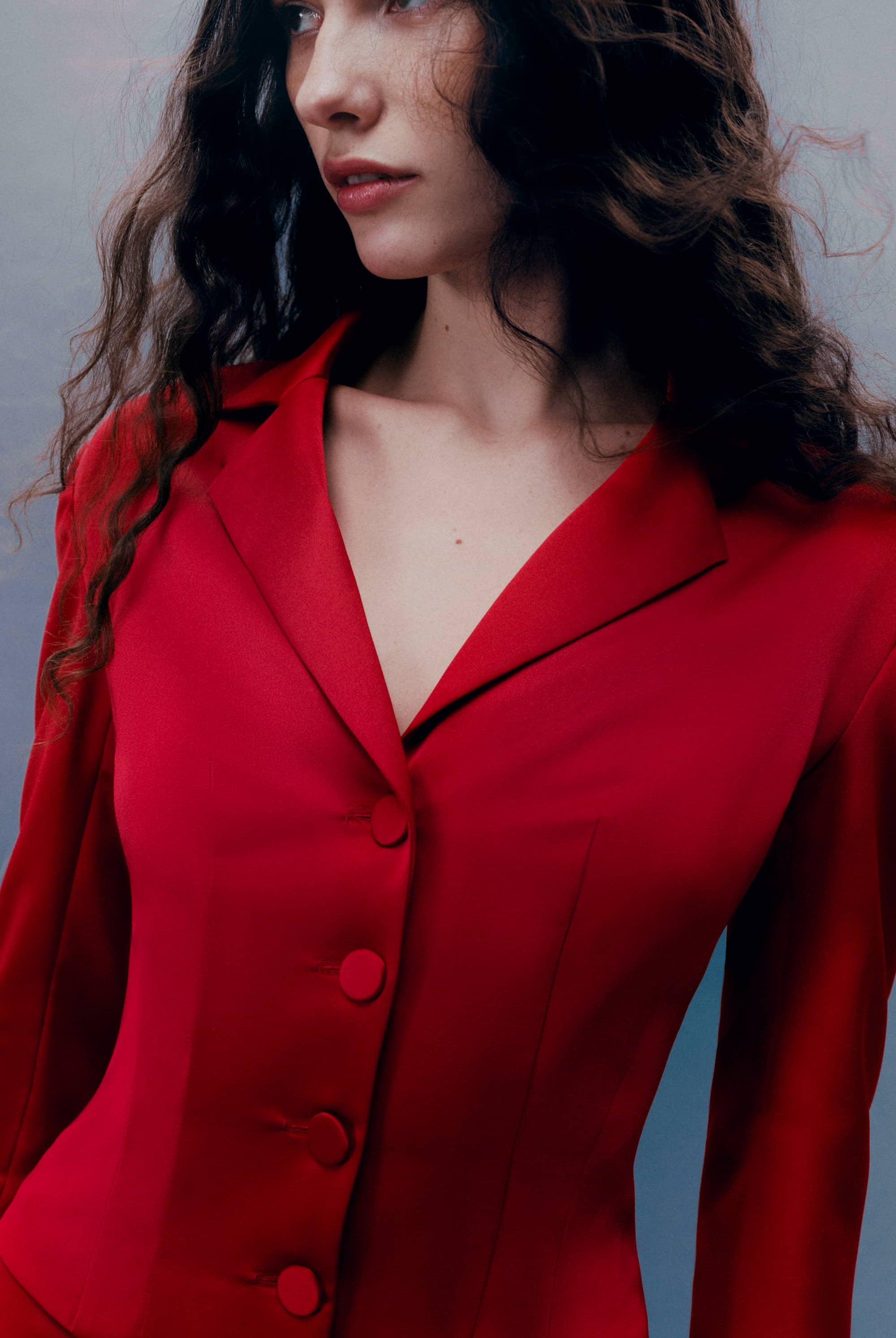 Woman wearing a red Giada jacket against a gray background