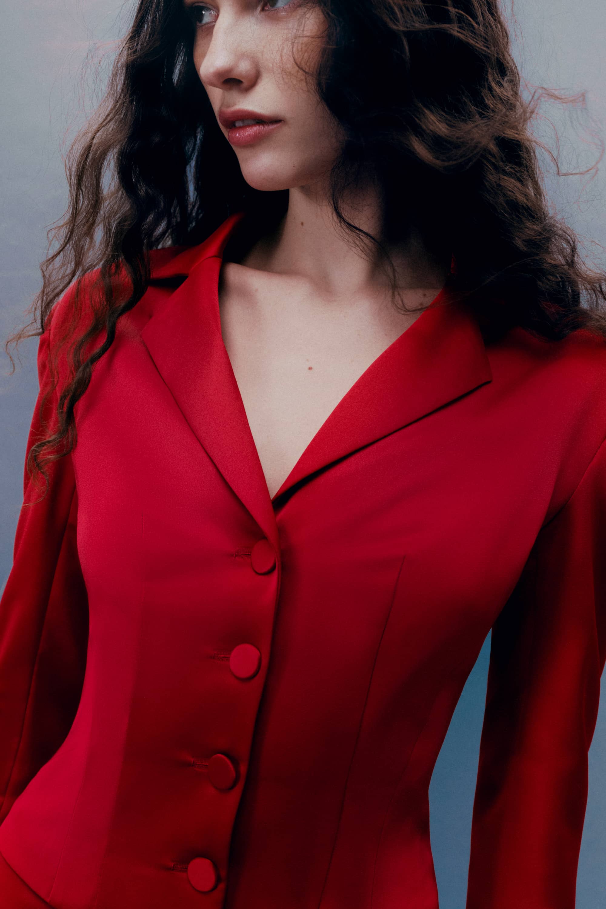 Woman wearing a red Giada jacket against a gray background