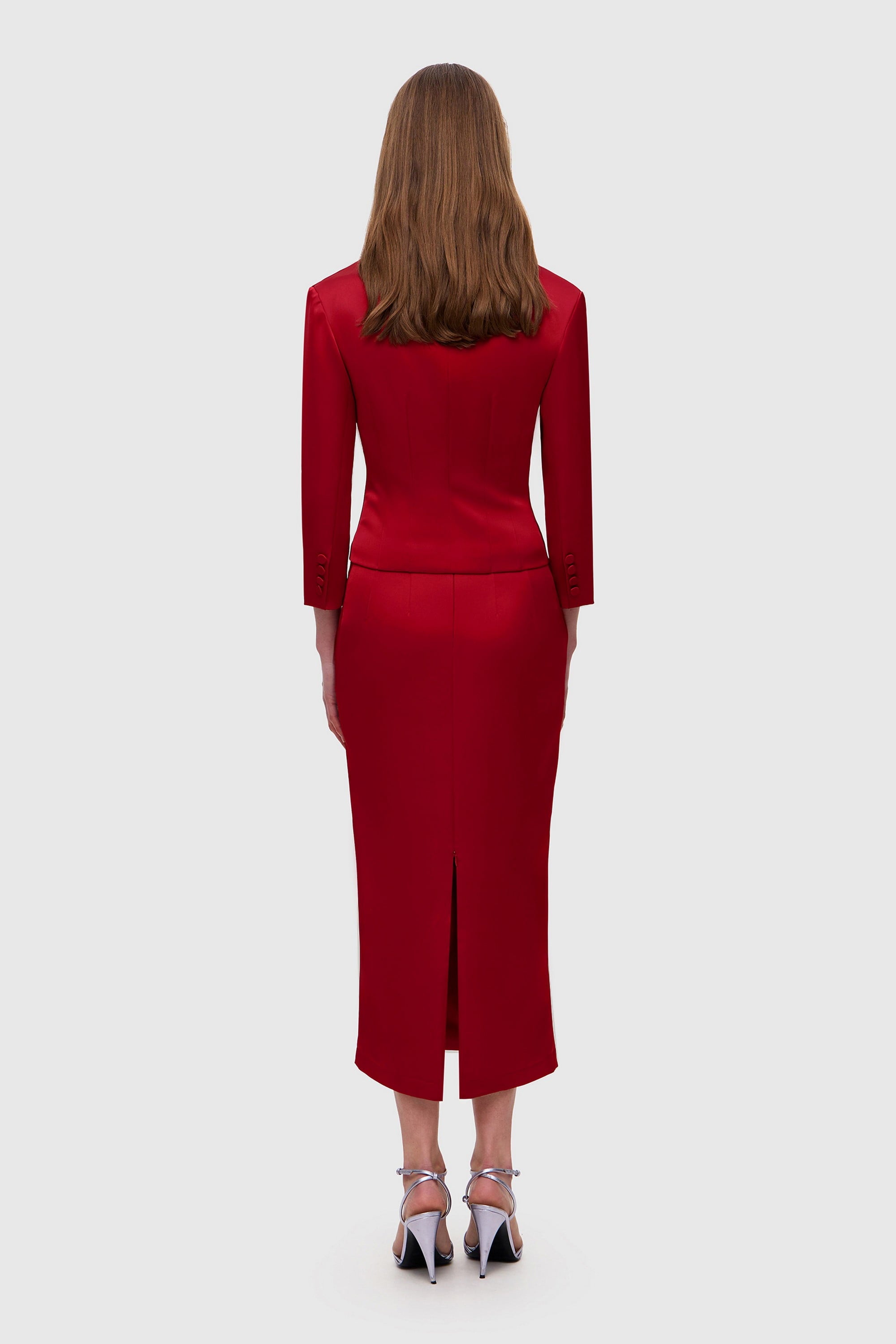 Woman wearing a red Giada jacket on a white background, back view