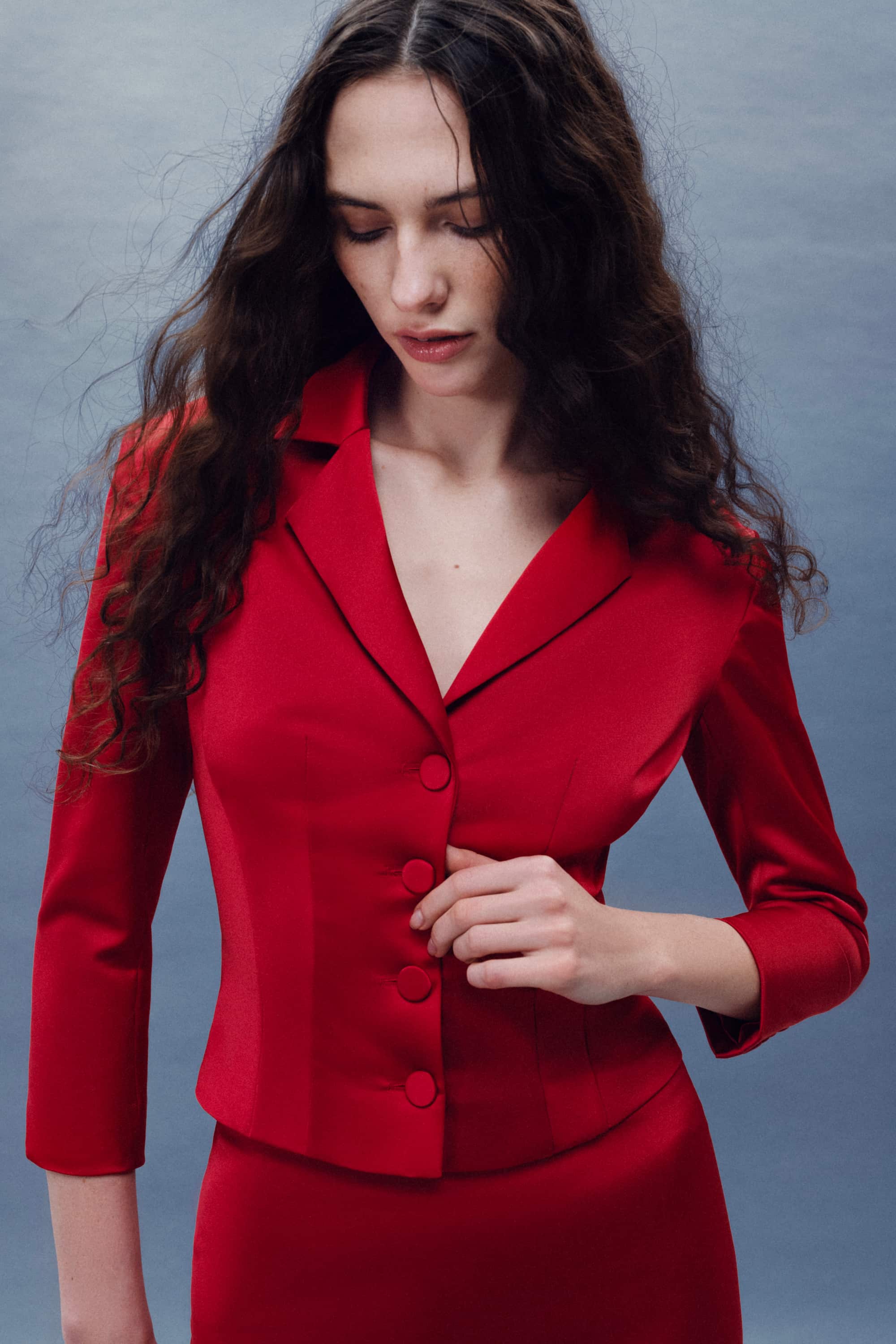 Woman wearing a red Giada jacket against a gray background