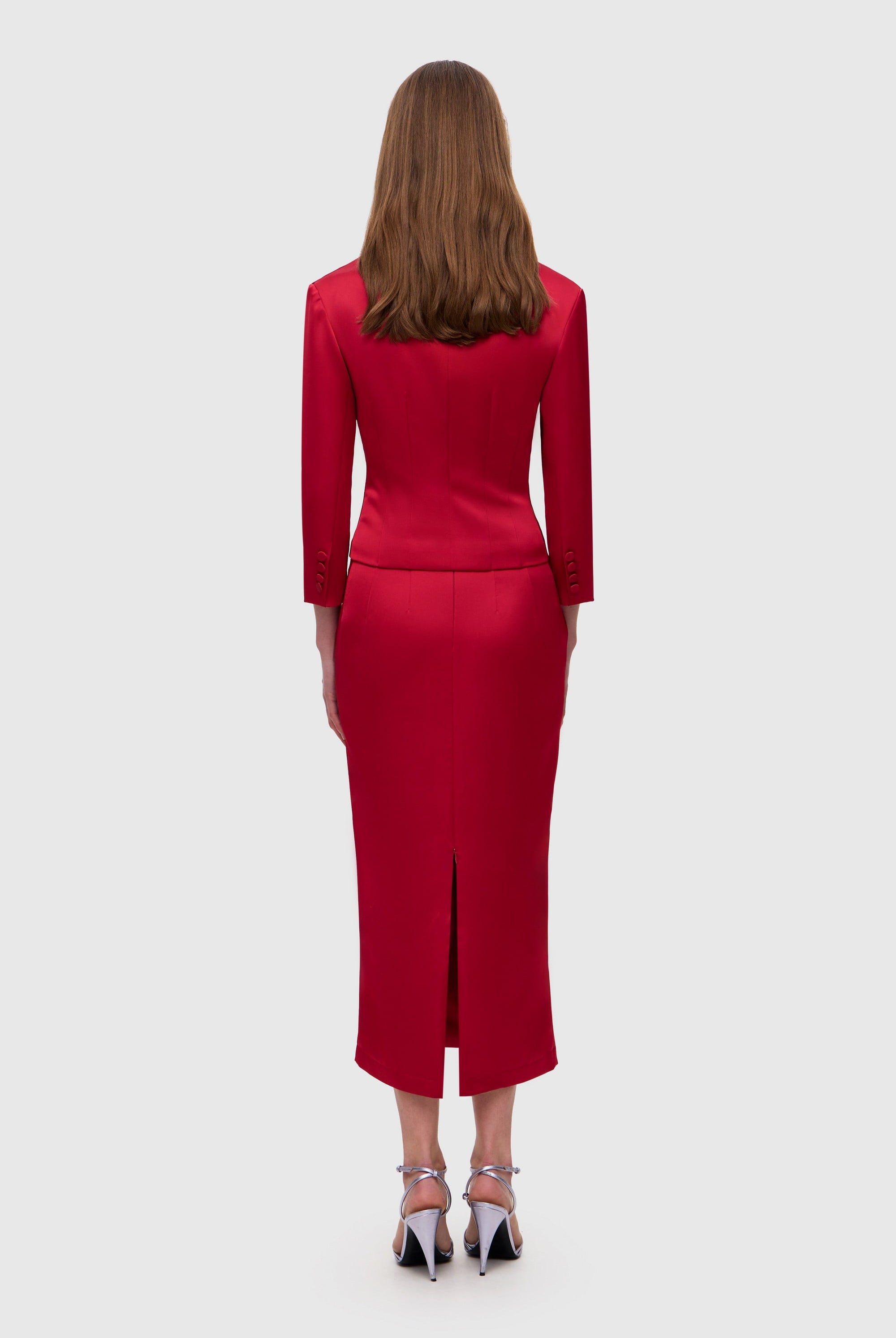 Woman wearing a red Giada jacket on a white background, back view