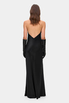 Model in open back Ruth maxi dress with decorative draping on the front, back view