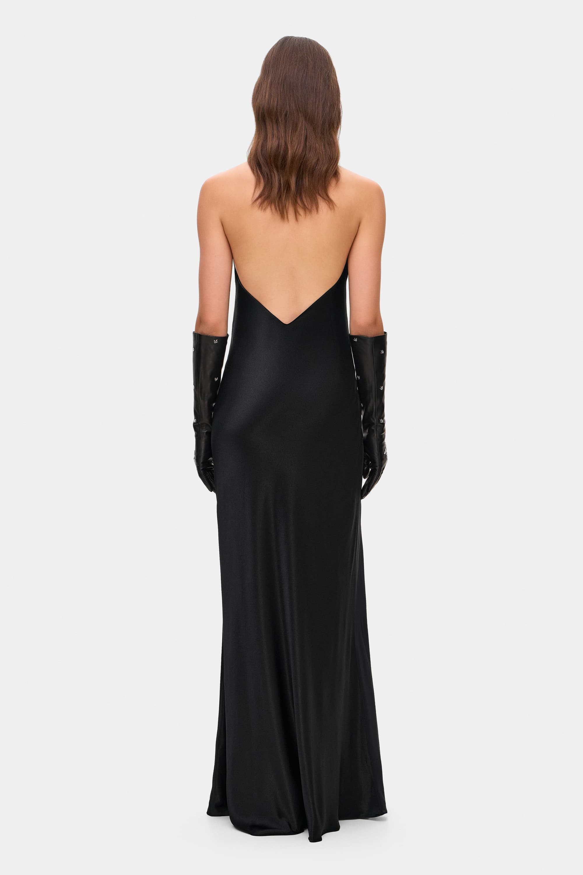 Model in open back Ruth maxi dress with decorative draping on the front, back view