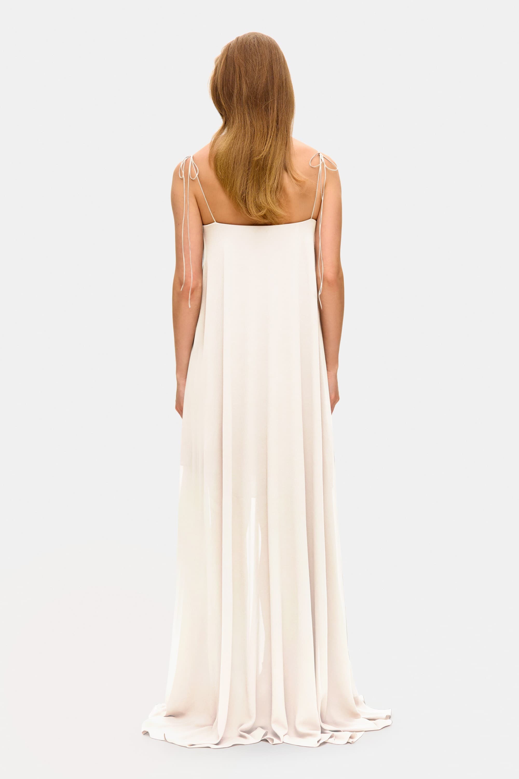 Model in Solomia maxi dress with tulip-shaped decorated cups and chiffon maxi sun skirt back view