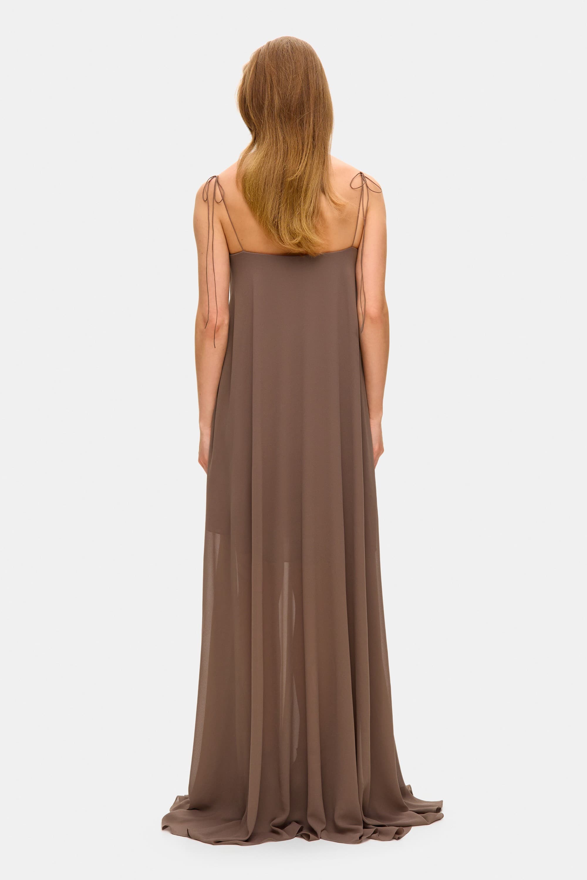 Model in Solomia maxi dress with tulip-shaped decorated cups and chiffon maxi sun skirt back view