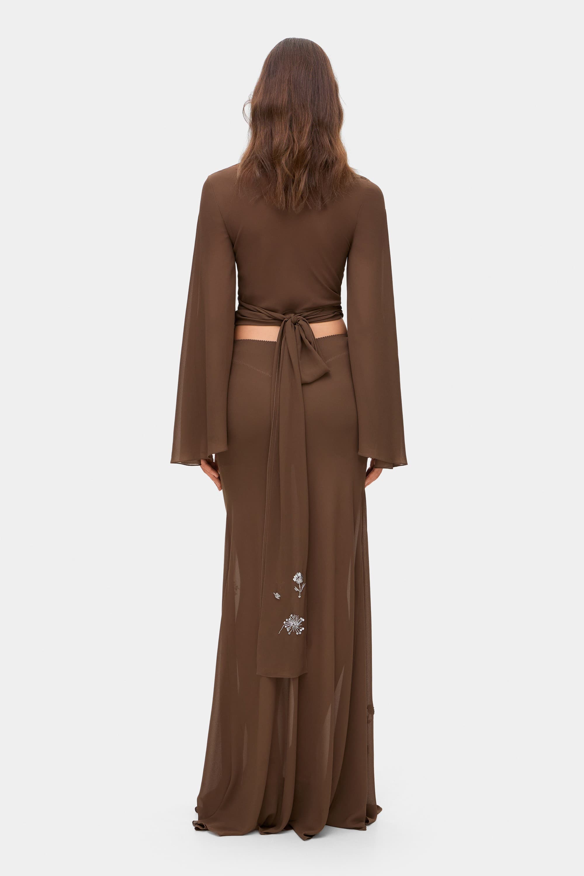 Model in wrap Marika blouse with embroidered sleeves back view