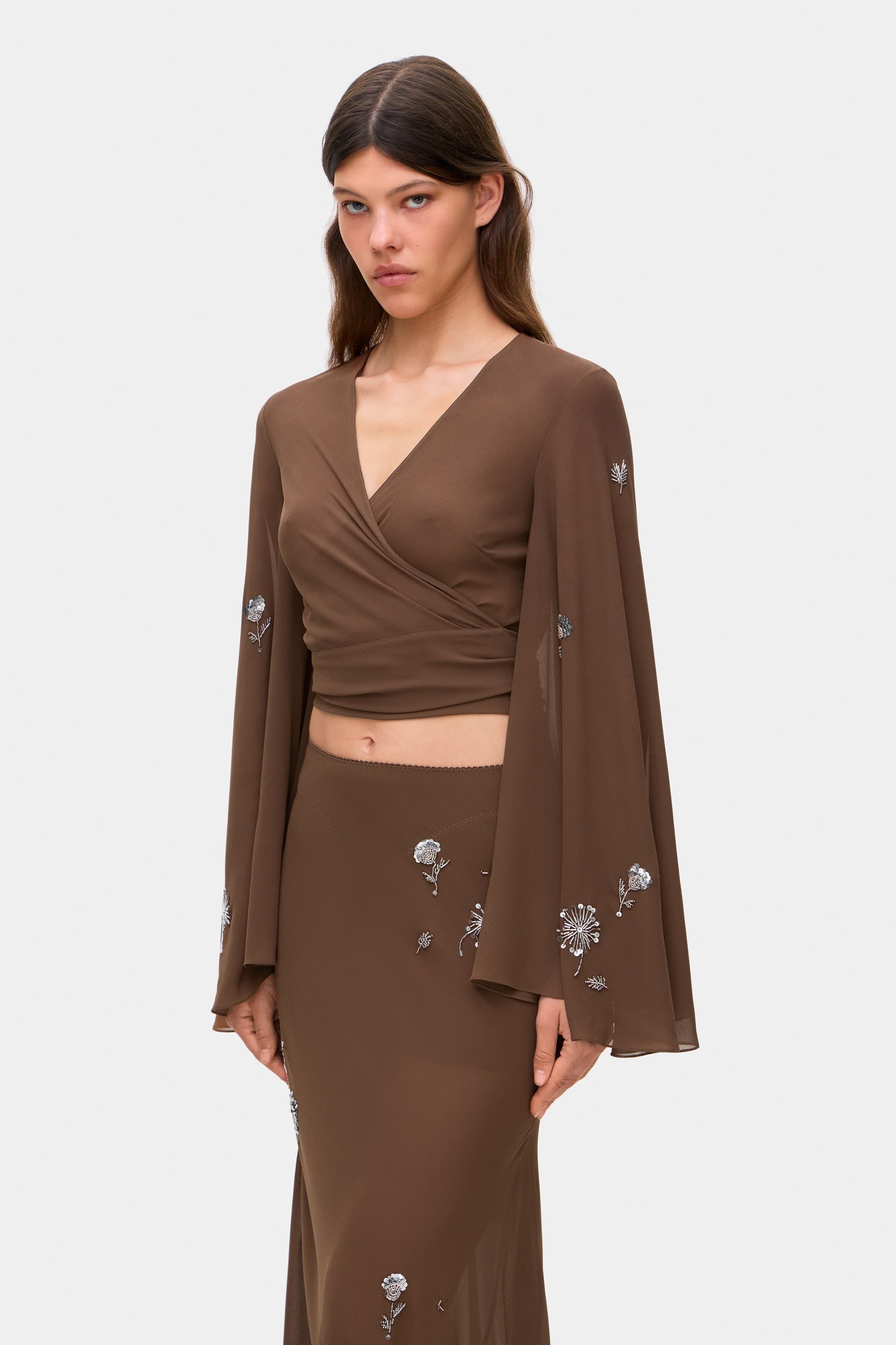 Model in wrap Marika blouse with embroidered sleeves side view