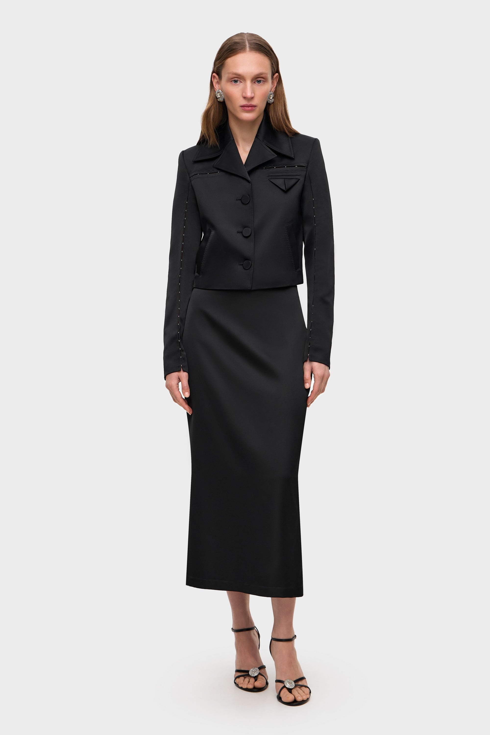 Woman wearing a black Nika jacket on a white background, front view