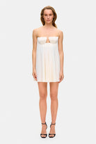 Model in loose Tonia mini dress with tulip-shaped decorated cups and straps tied into bows front view