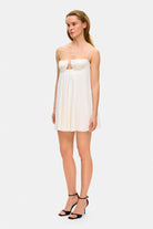 Model in loose Tonia mini dress with tulip-shaped decorated cups and straps tied into bows side view
