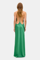 Model in open back maxi Justina dress with flowing design and a slit back view