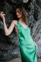 Model in open back maxi Justina dress with flowing design and a slit