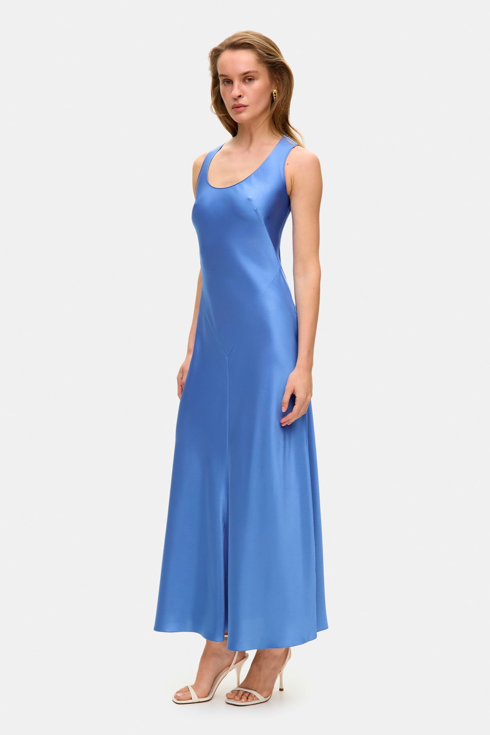 Model in midi fitted Lydia dress with a flared shape starting from the hips side view