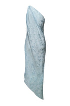 A light blue asymmetrical draped Rina dress with a textured subtle tonal floral pattern, shown against a plain white background, front view