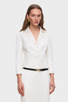 Woman wearing a white Giada jacket with a black belt on a white background, front view
