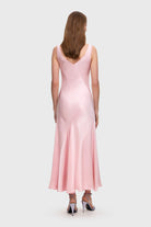 Woman wearing a pink Liza dress on a white background, back view