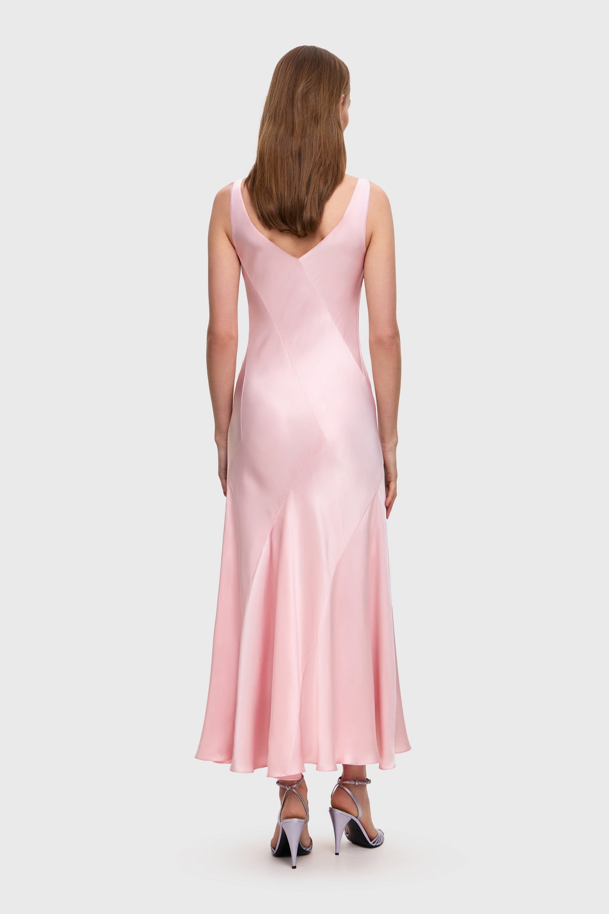 Woman wearing a pink Liza dress on a white background, back view