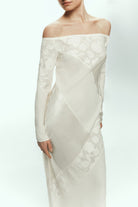 Woman wearing a white off-shoulder Santa dress with floral patterns on a white background, front view details