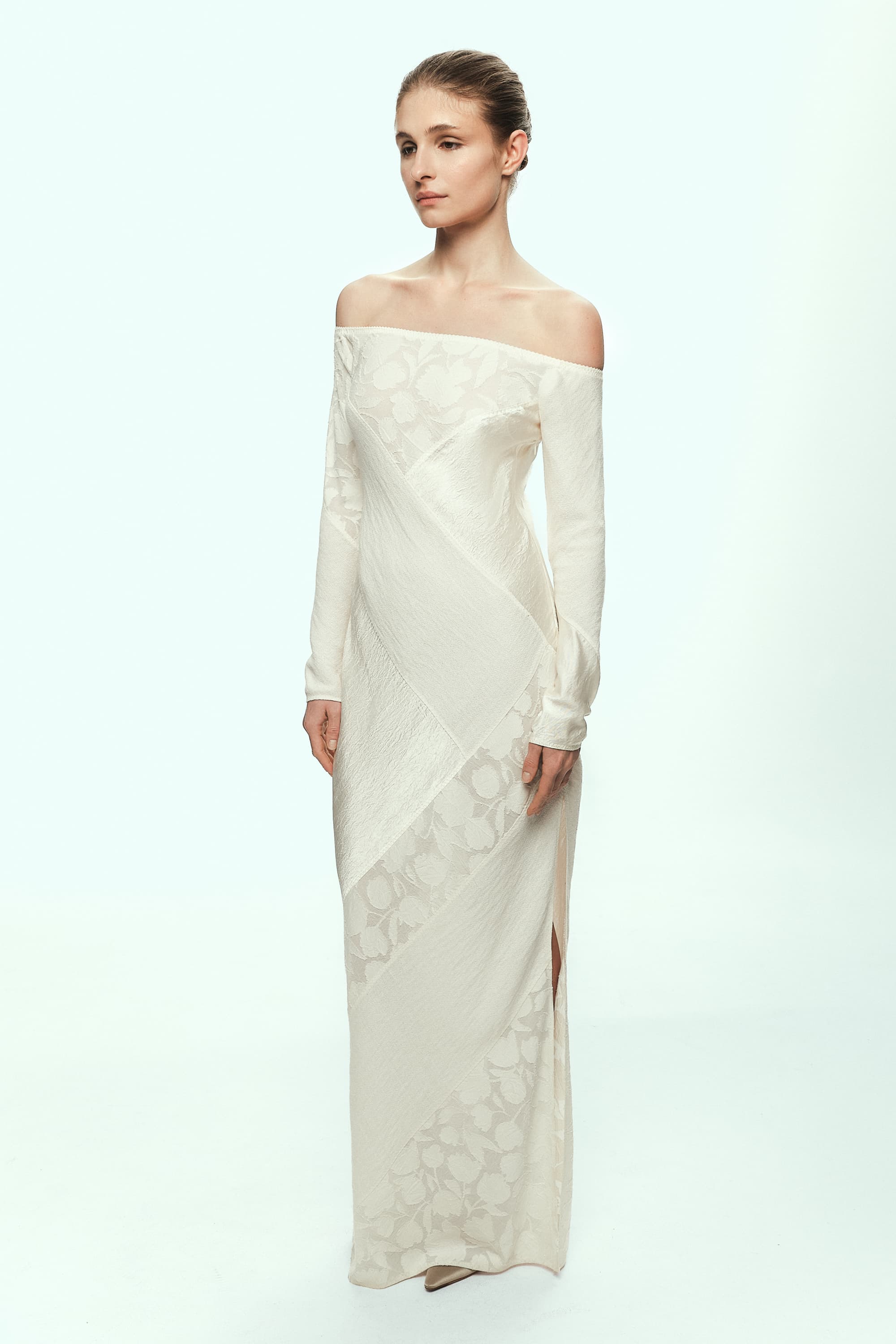 Woman wearing a white off-shoulder Santa dress with floral patterns on a white background, front view