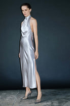 Woman wearing a silver halter neck Jordana dress against a dark background