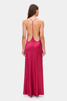 Woman wearing a berry Justina dress on a white background, back view