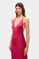 Woman wearing a berry Justina dress on a white background, front details view