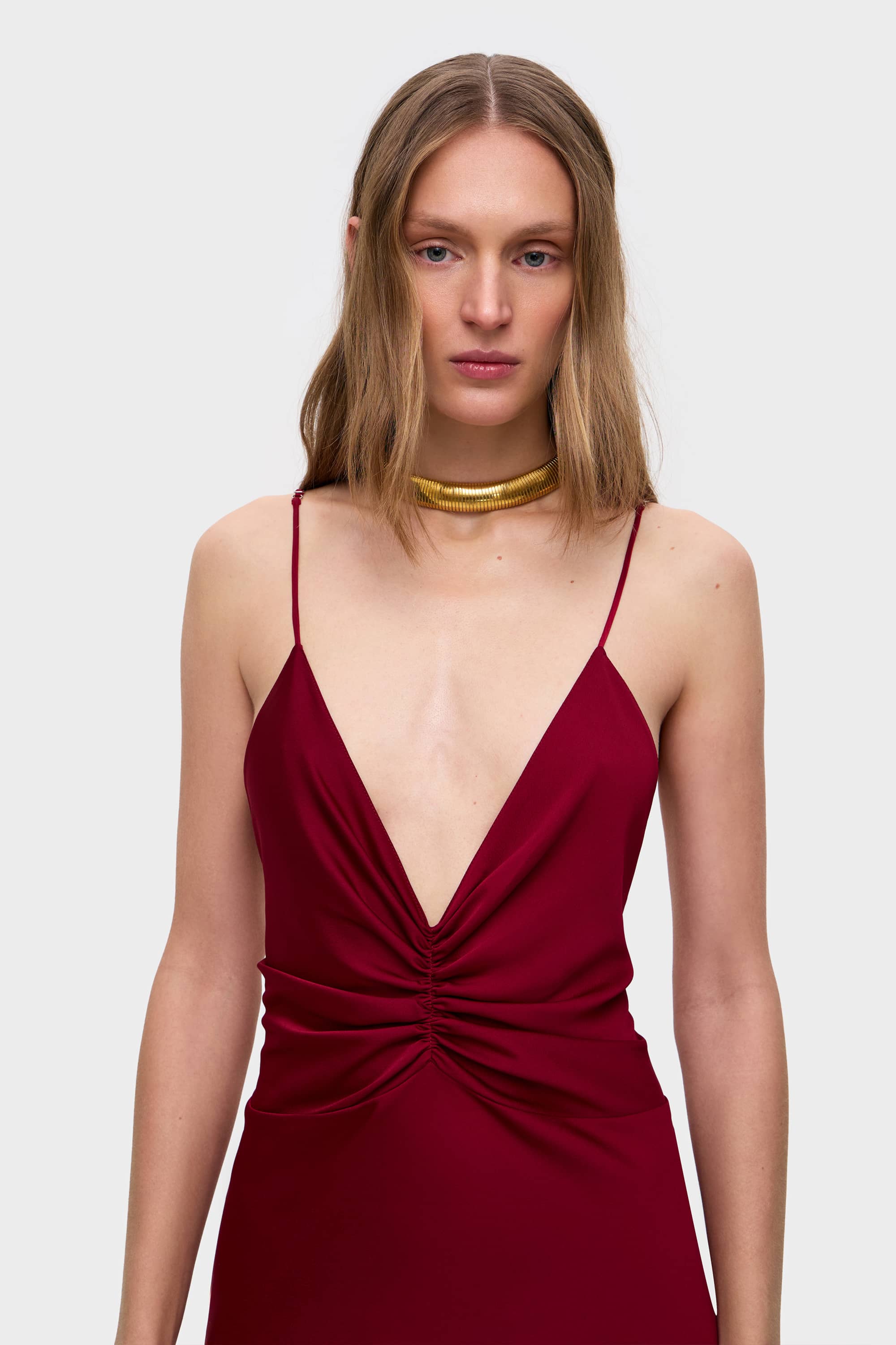 Woman wearing a berry Maltina dress on a white background, details front view