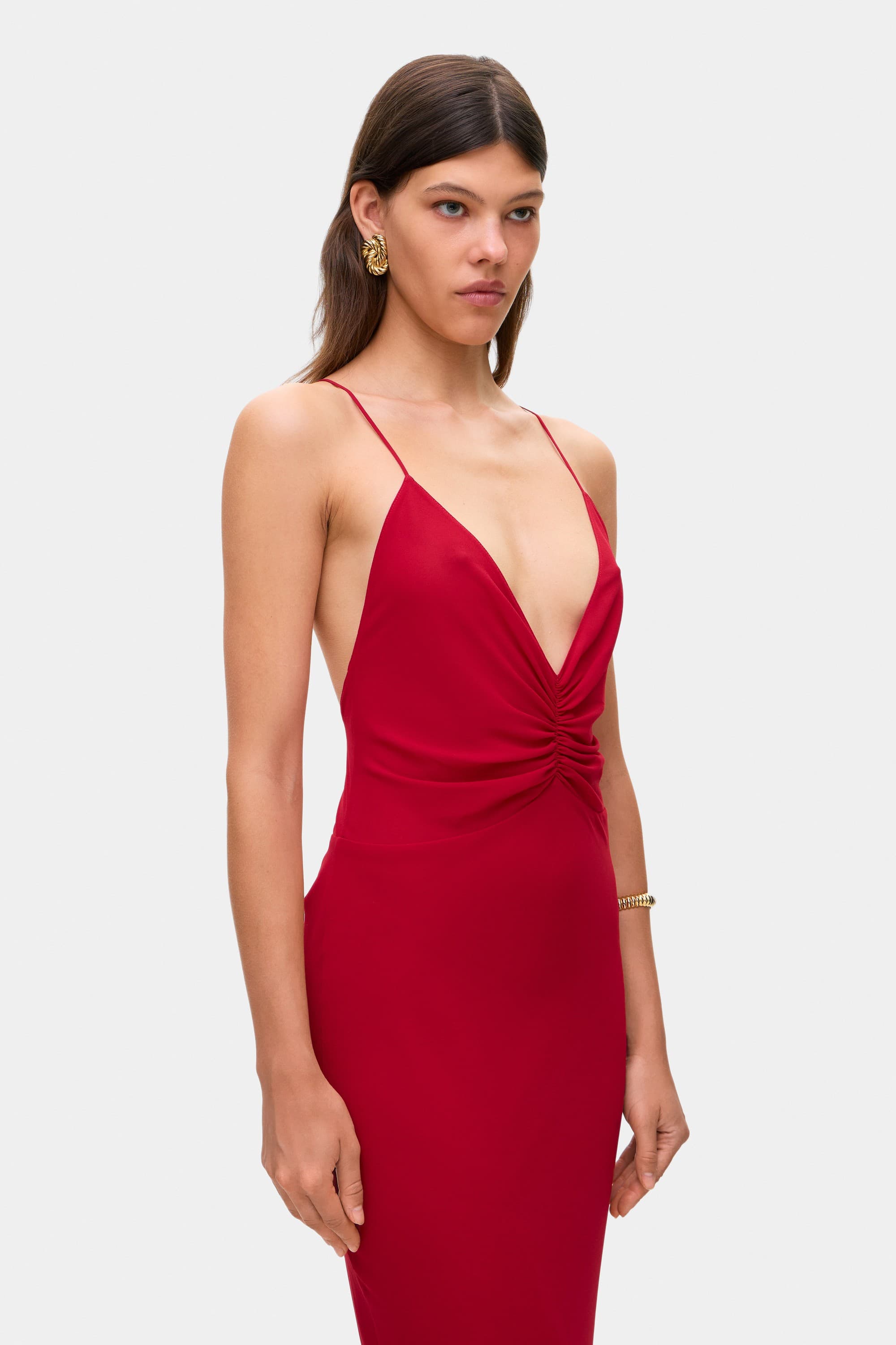 Woman wearing a berry Maltina dress on a white background, side details view