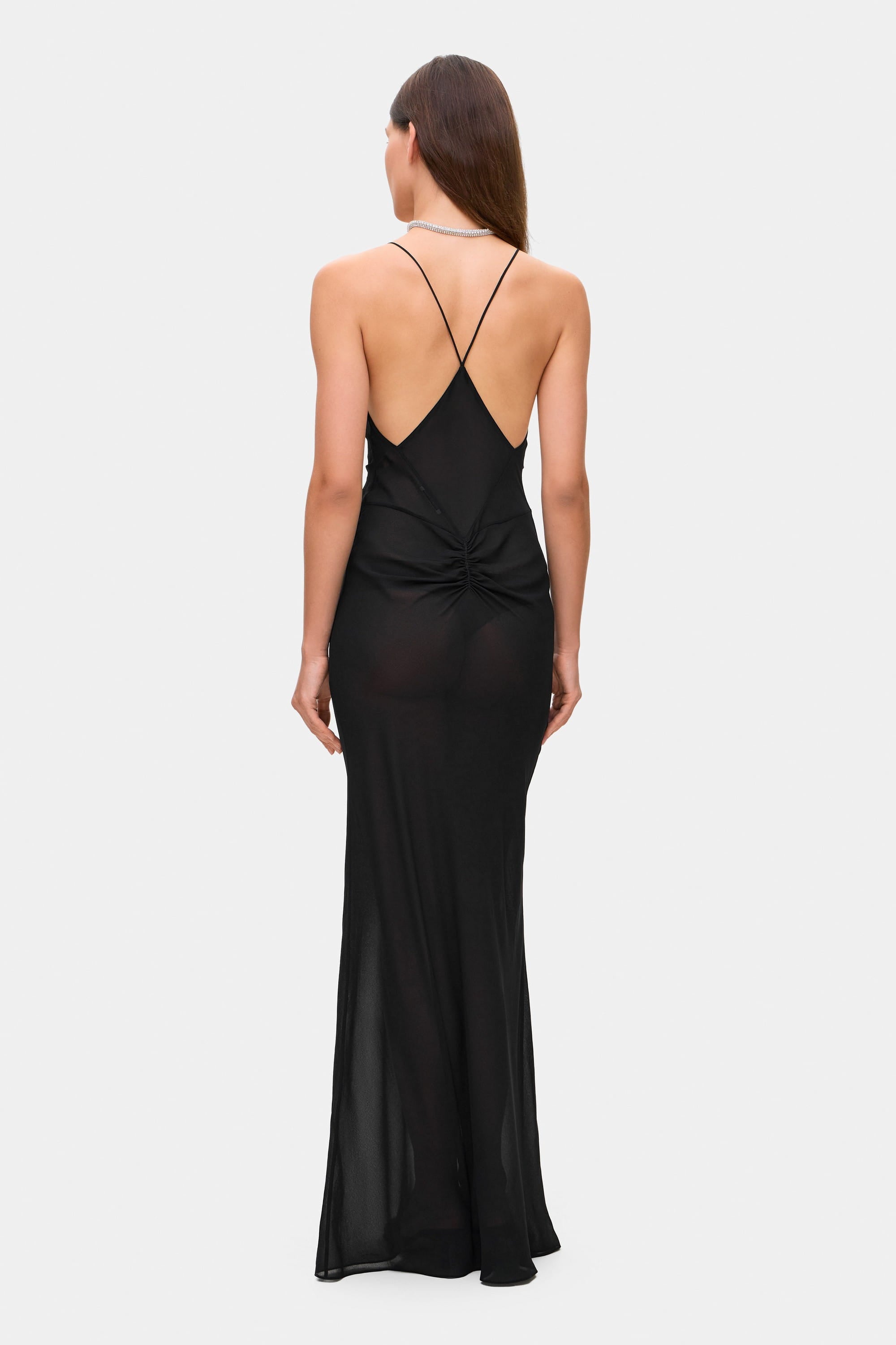 Woman wearing a black Eliana dress on a white background, back view