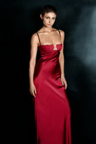 Woman wearing a berry Tulip dress against a dark background, front view