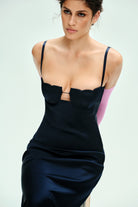 Woman wearing a blue Tulip dress with a bow detail on a light gray background