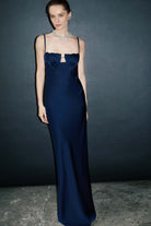 Woman wearing a blue Tulip dress with a textured bodice against a green-gray background