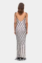 Woman wearing a ivory and black netted patterned with thin straps Helena dress on a white background, back view