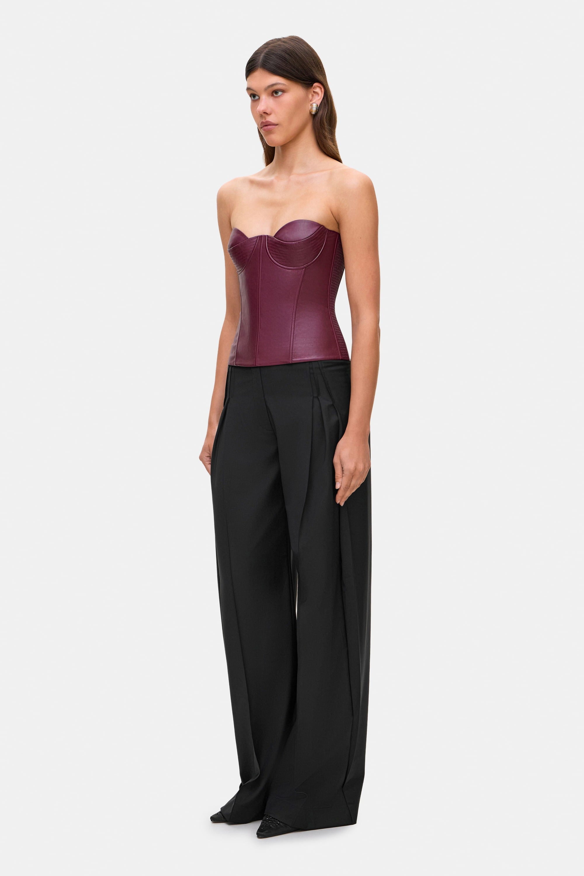 Woman wearing a black wide-leg Katherine pants on a white background, side view
