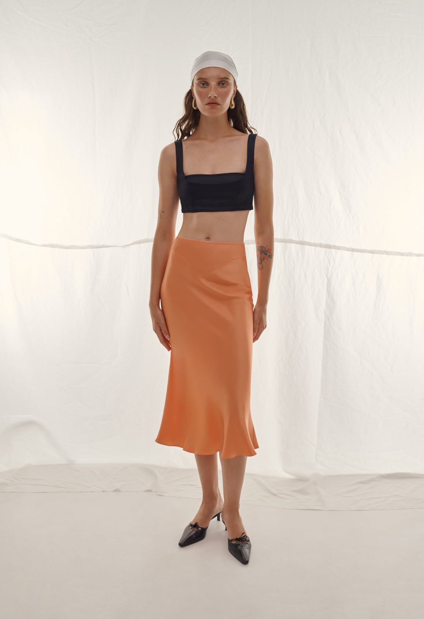 Model in orange Voleta skirt
