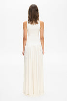 Model in knitted maxi silhouette Arpha dress with wide skirt back view