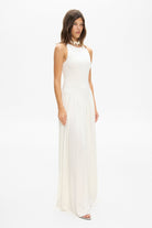 Model in knitted maxi silhouette Arpha dress with wide skirt side view