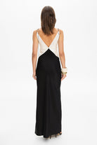 Model in maxi contrast Terrin dress on straps with a cut on the bodice back view